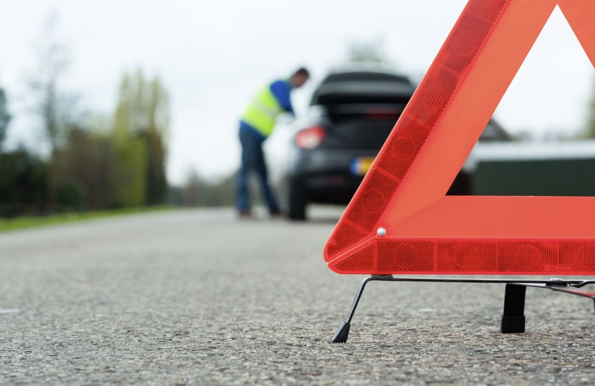 Professional roadside assistance technician helping a stranded motorist in Brookline, MA
